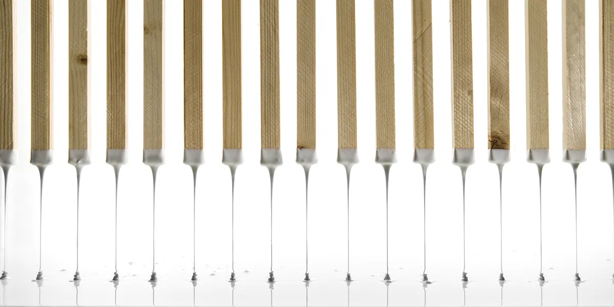 Row of brushes dripping with white glue
