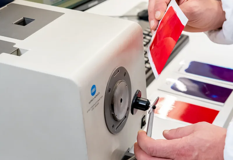 Technician measuring the colour of a coated sample with a spectrophotometer
