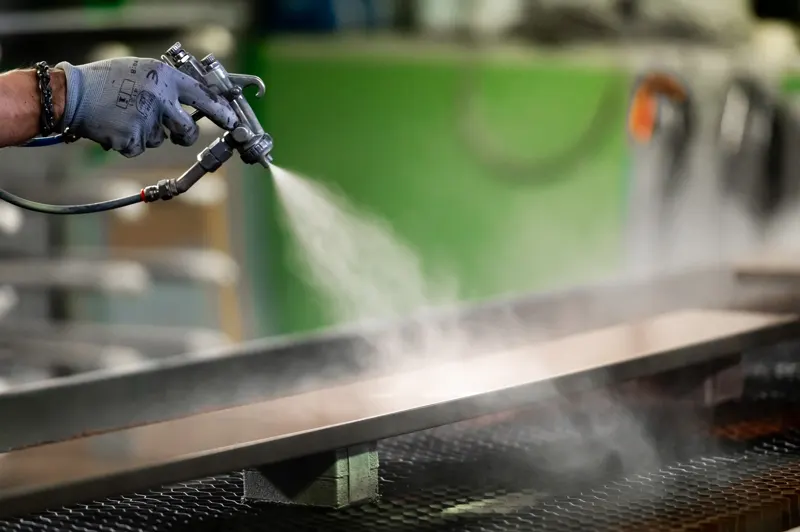 Spray application of a coating on an industrial line